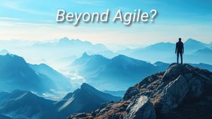 “An individual stands on a rocky mountain peak overlooking a vast landscape of rolling blue mountains beneath a bright, clear sky. The text ‘Beyond Agile?’ appears in white with a slight shadow, giving a sense of exploration and looking forward to new horizons beyond Agile methodologies.”